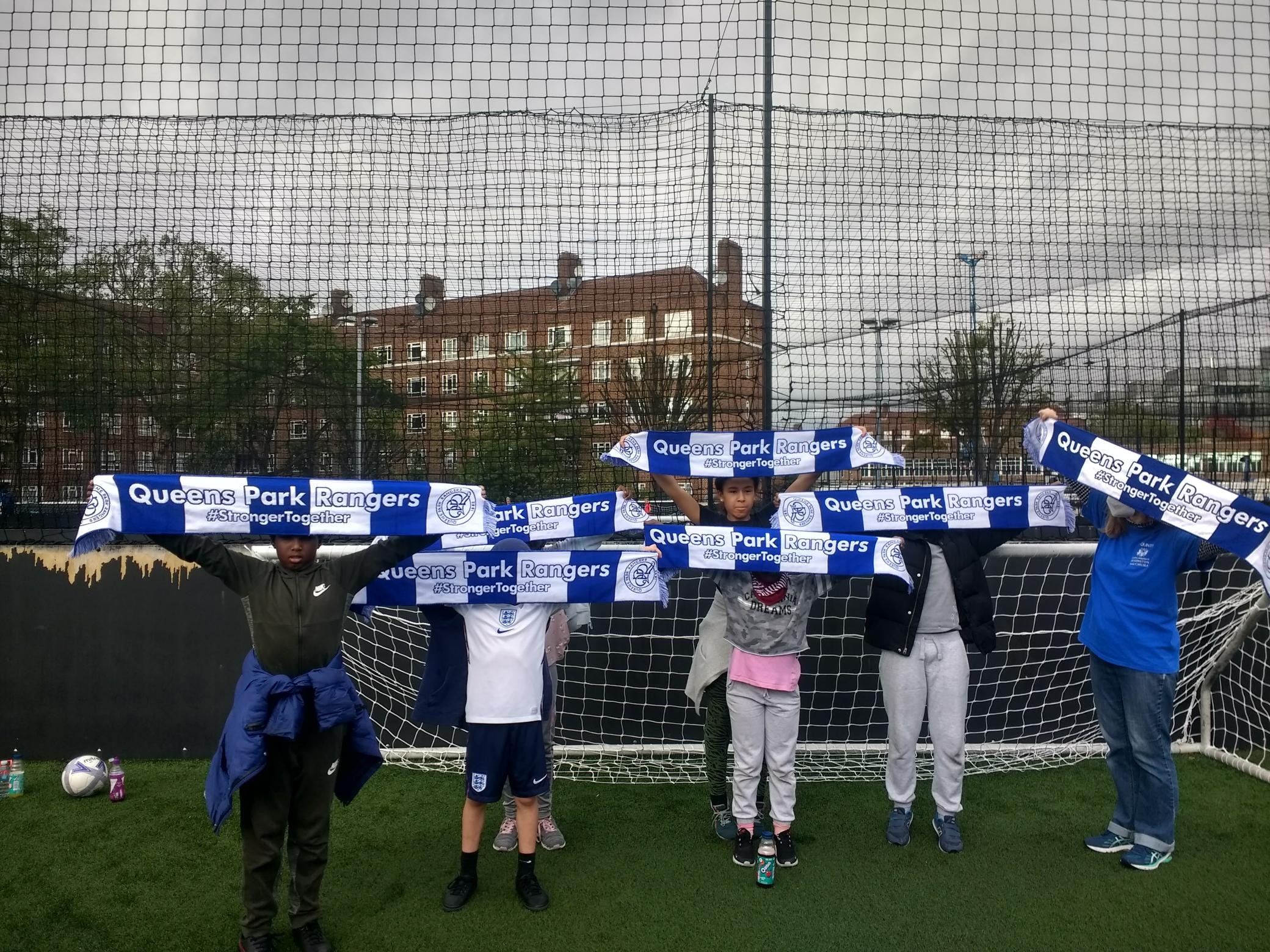 The children holding up QPR banners across their faces